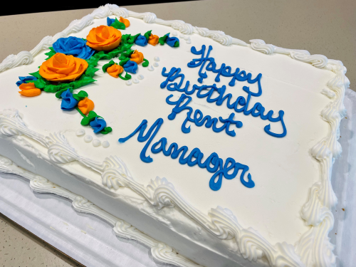 A birthday cake with "Happy Birthday Rent Manager" written in frosting