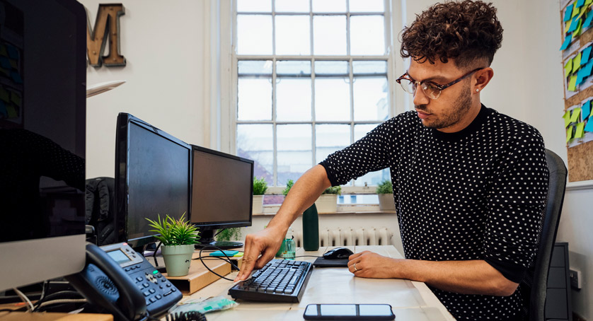 A man cleaning his desk to improve mental health benefits of a clean workspace