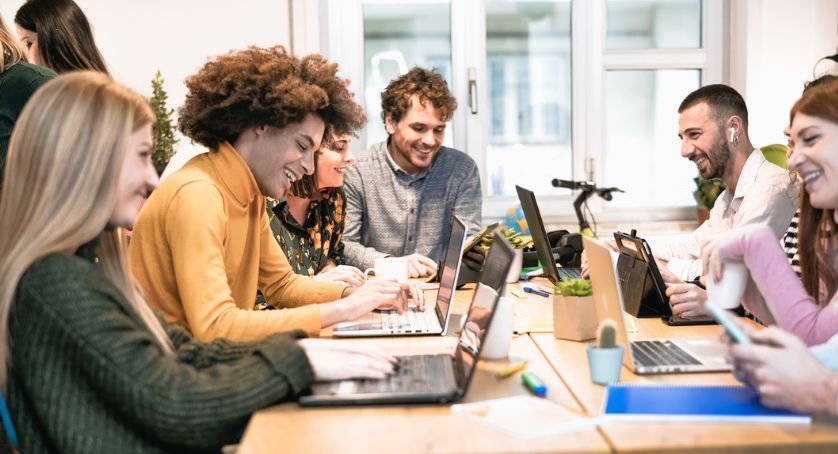 A group of people building workplace culture smiling laughing 