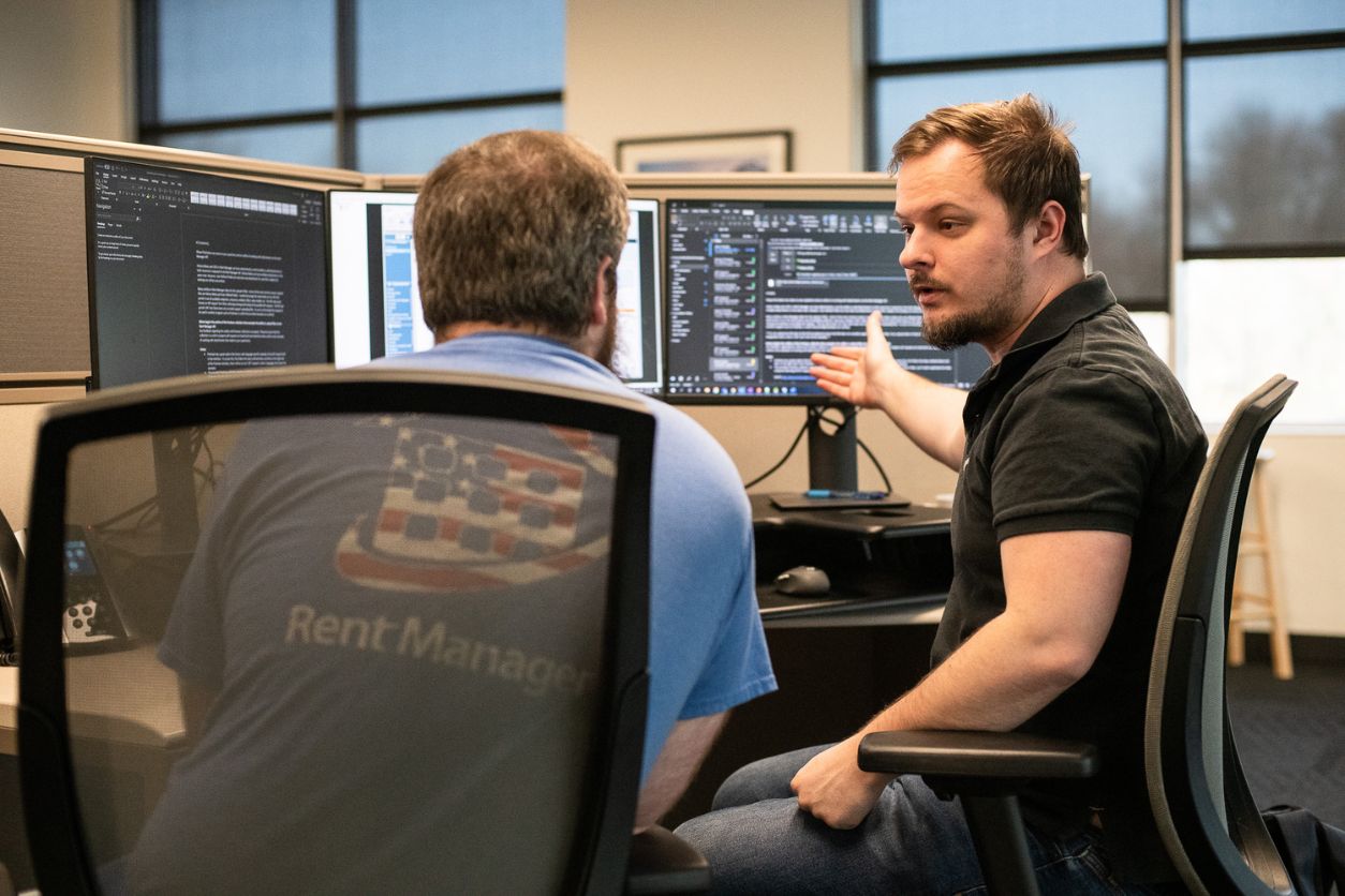 LCS employees at a desk collaborating, pointing at the computer.