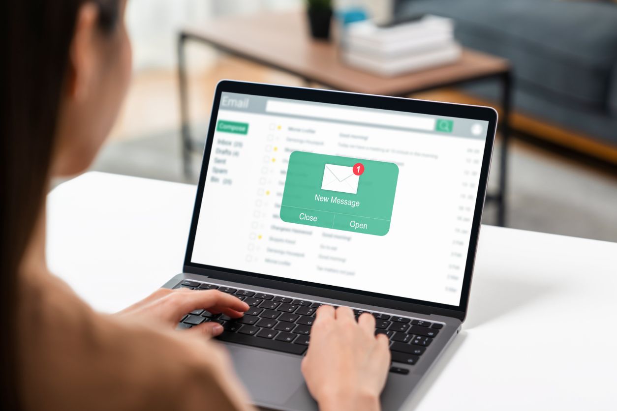 Woman using computer on table with new email message on laptop, communication connection message to global letters in the workplace